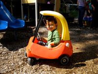 little boy in toddler plastic play car