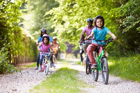 family bike ride on wooded path