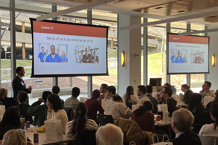 Dr. Cox delivers a talk before medical students.