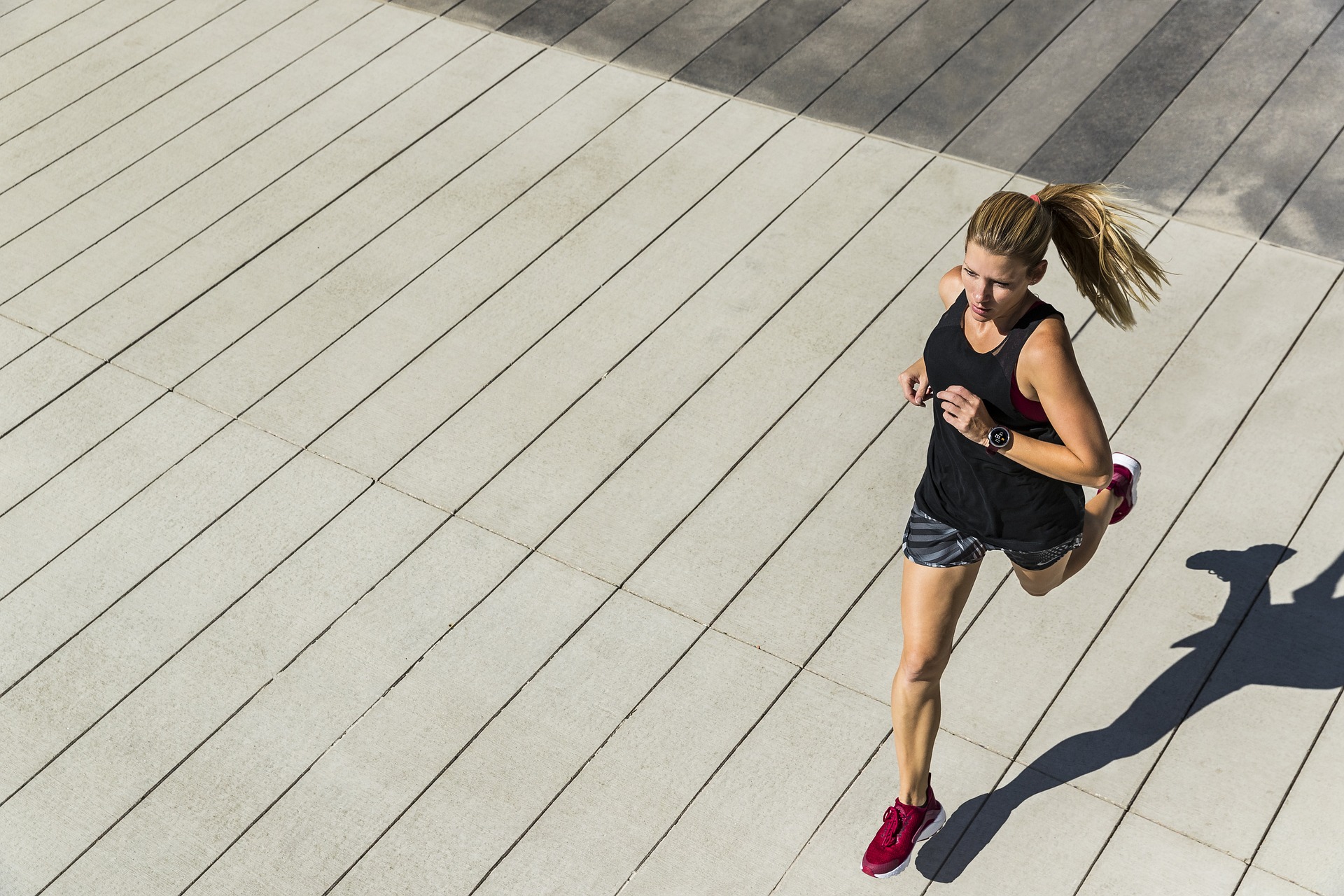 a woman running on concrete, as viewed from above