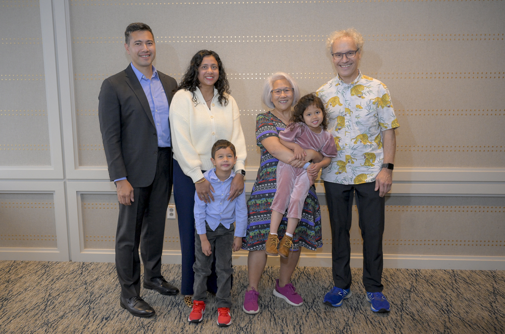 Ambros and Lee stand with their son, daughter-in-law and grandchildren at the UMass Club in Boston on the day of the Nobel announcement.