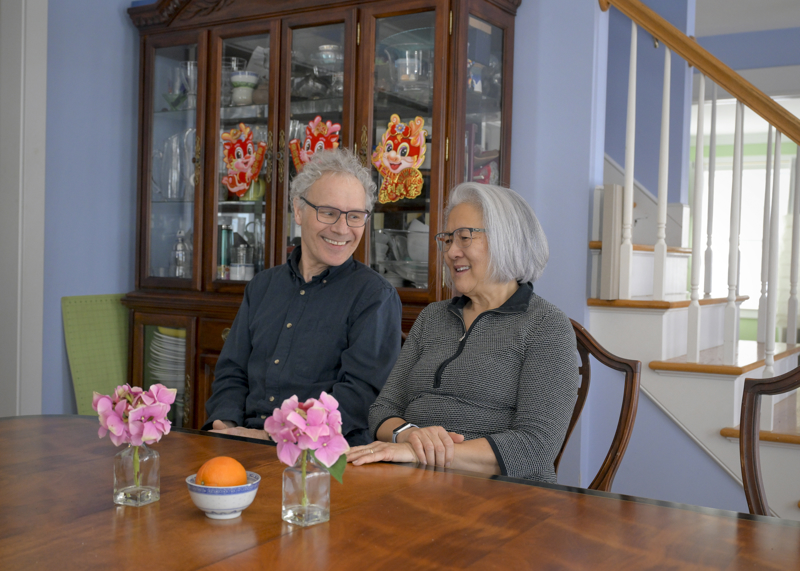 Victor Ambros and Rosalind “Candy” Lee sit together at a table in their home