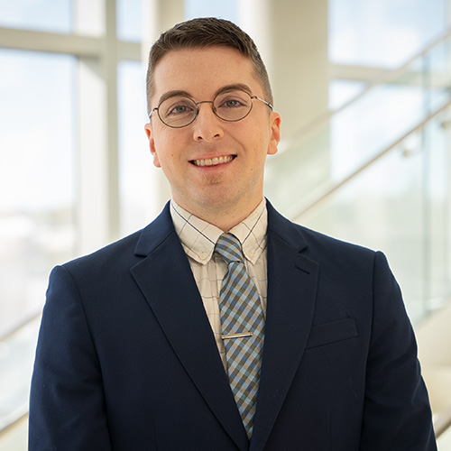 white male with dark hair wearing glasses