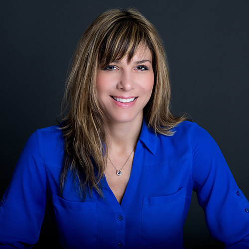 white woman brown hair wearing blue blouse