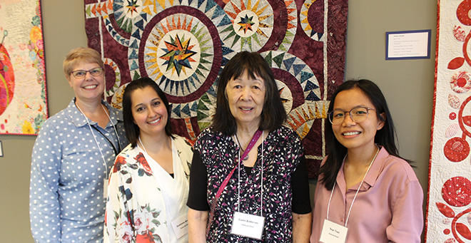 Mary Piorun, Dihiana Angel, Gwen Anderson and Tran Tran with one of Piorun’s quilts. 