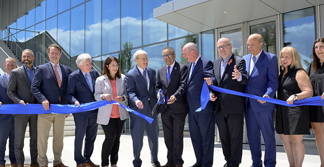 Group shot of ribbon cutting in front of the new building