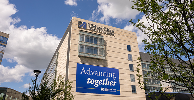 UMass Chan Medical School building with a sign on it that says Advancing together