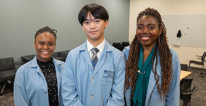 Three Summer Enrichment Program students together in blue coats